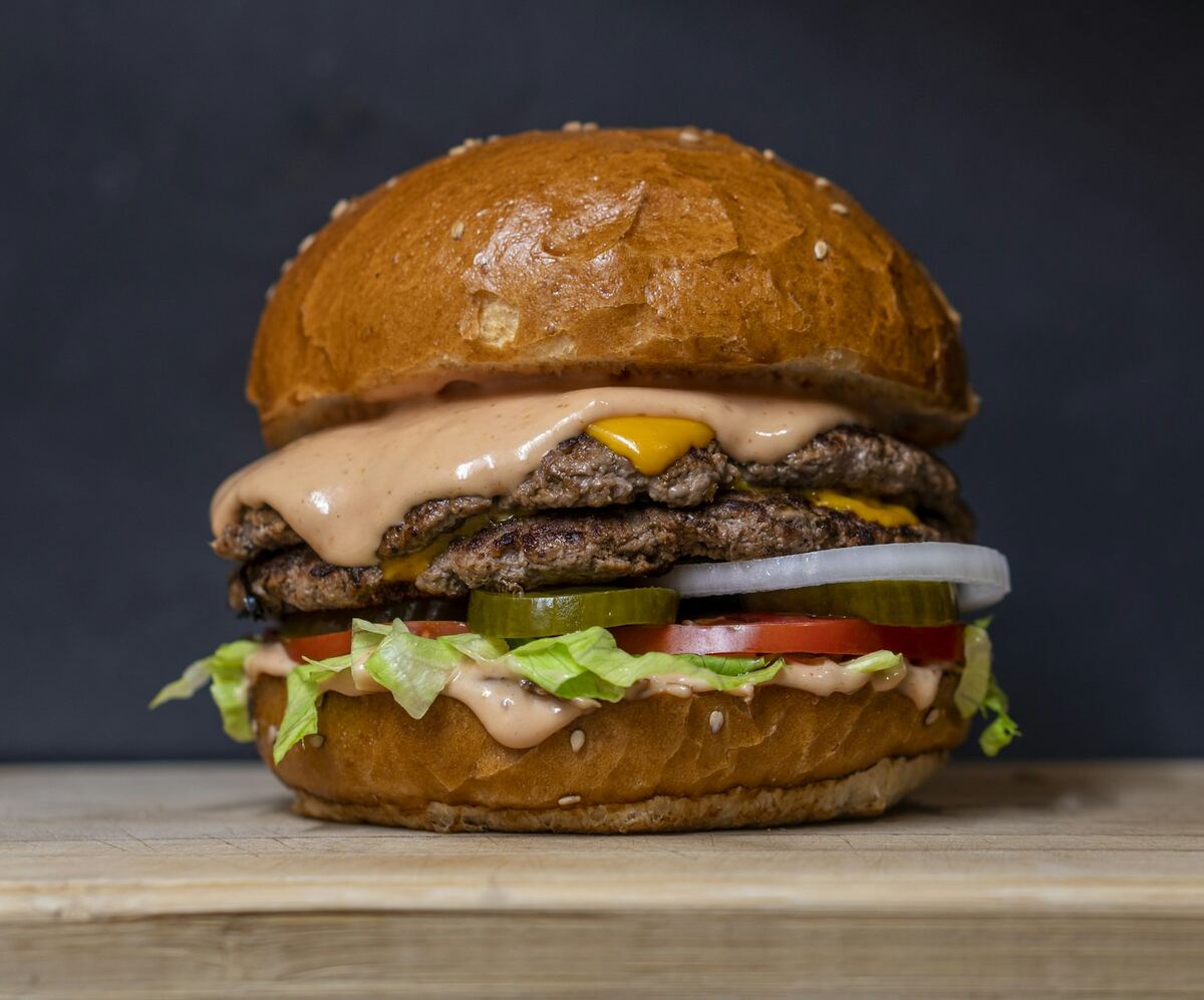 Burger gourmand photographié en gros plan, lumière naturelle latérale