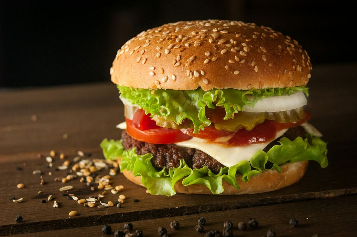 Burger généreux photographié en gros plan, pain brioché doré et steak juteux
