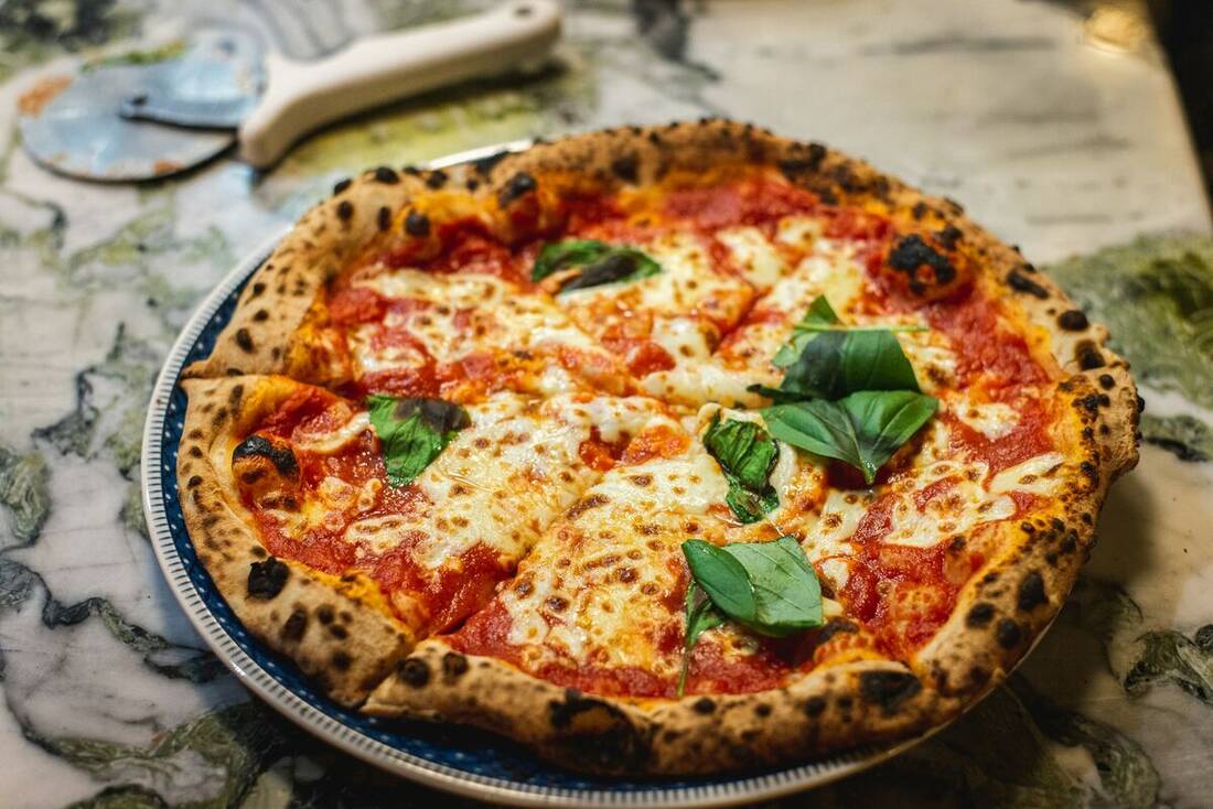 Pizza napolitaine margherita au feu de bois, mozzarella fondante et basilic frais